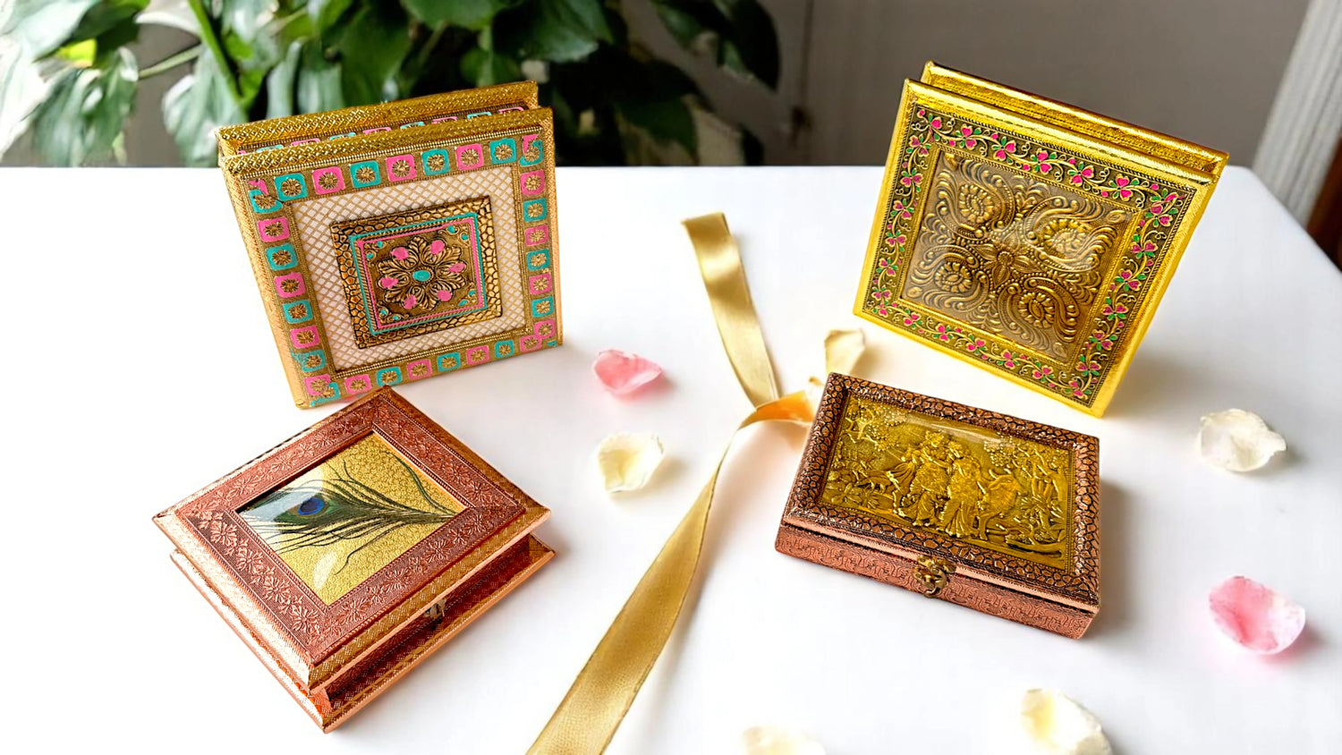 Elegant handcrafted wooden gift boxes with intricate traditional Indian designs, ideal for festive gifting, wedding favors, and premium packaging – displayed on a white table with flower petals and a golden ribbon.